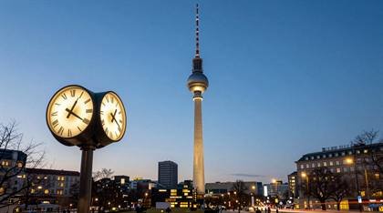 Fernsehturm mit Straßenuhr am Abend