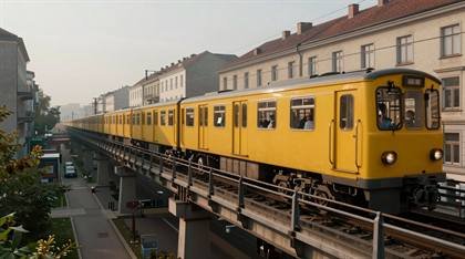 Gelbe U-Bahn auf der Hochbahn bei Tageslicht