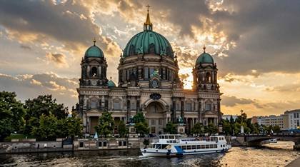 Berliner Dom mit Ausflugsschiff im Sonnenuntergang